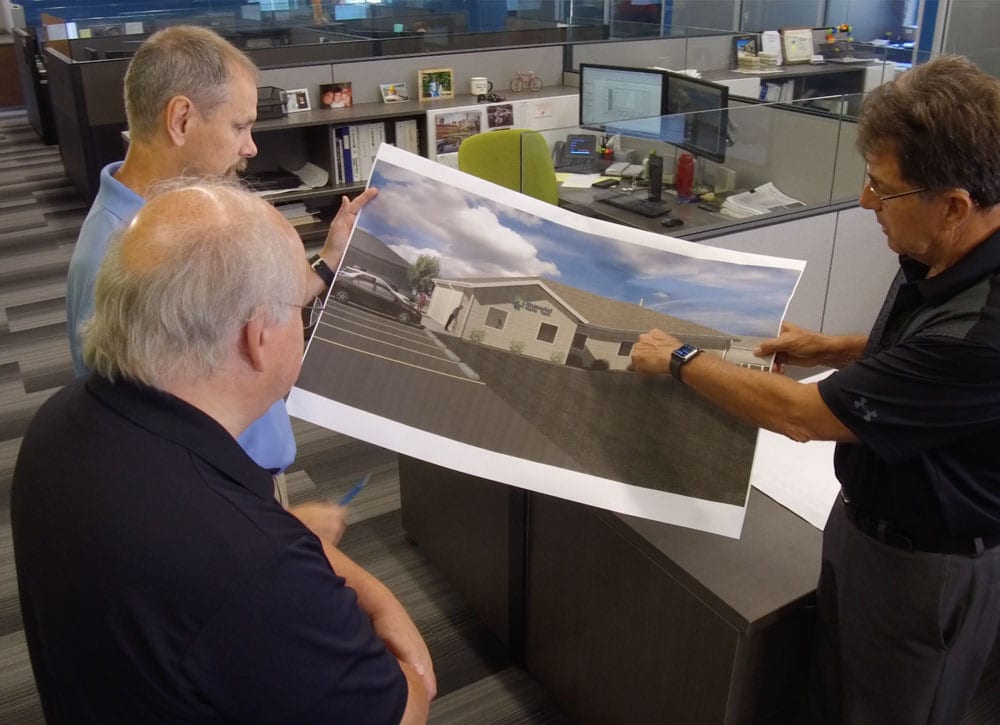 Men reviewing large rendering of building Men reviewing large rendering of building